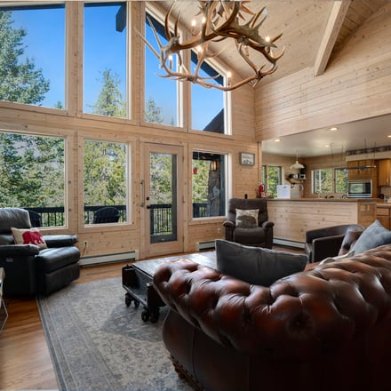 Cozy cabin living room with stone fireplace and timber beams